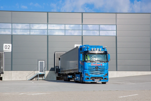 Ein blauer LKW der Spedition Gelhart am Firmengelände