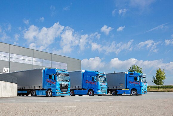 Drei blaue LKWs der Transport & Logistik Gelhart GmbH